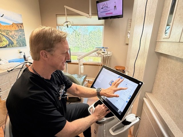 Dentist at Select Care Dental reviewing a digital 3D scan of a patient's teeth on a chairside monitor